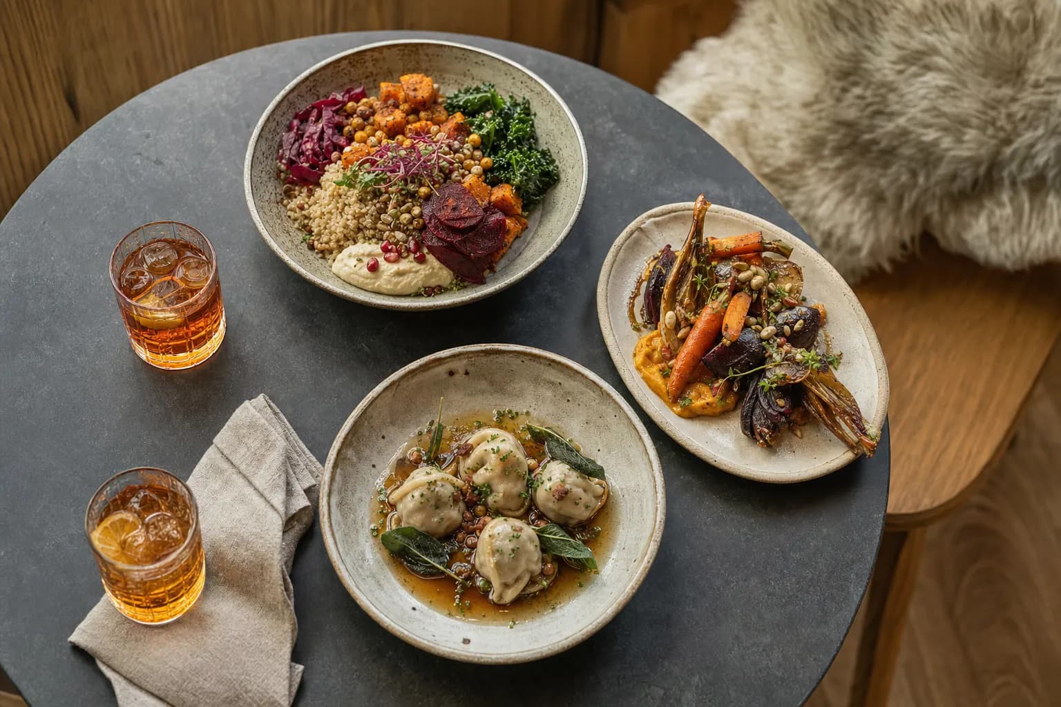 Moderne Bistrogerichte und alkoholfreie Aperitifs auf einem dunklen Steintisch